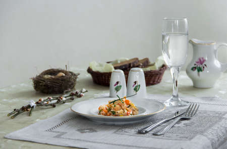 A plate vegetable stew with glass fork knife, willow branches, quail eggs, salt and pepper.の写真素材