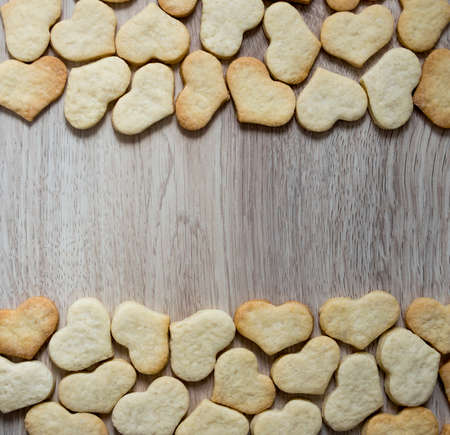 on a wooden background top and bottom lie cookies gingerbread sand ginger heartsの写真素材
