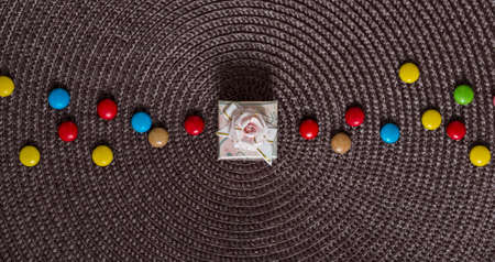 on a napkin in the center gift box with a bow next to a candy colored