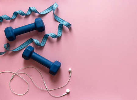 on a pink background dumbbells blue and flying centimeter figure sport headphones music soft lightの写真素材
