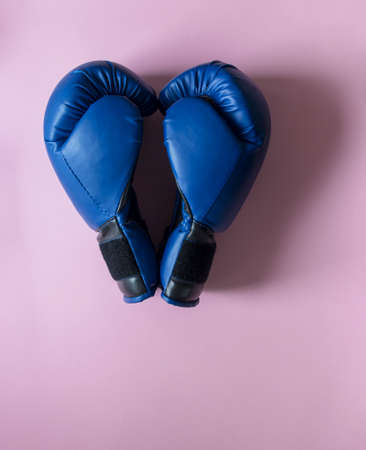 on a pink background two boxing gloves of blue color in the sight of the heartの写真素材