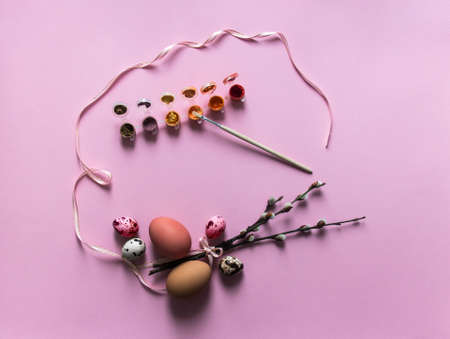 on a pink background, willow branches blossomed eggs quail chicken dyed red pink color view from above ribbon pink oval paint brushの写真素材