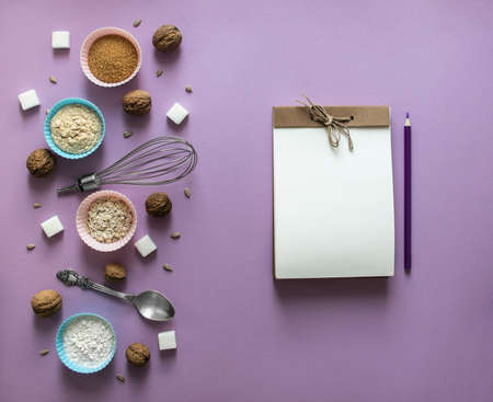 on a lilac background on the left laying out chaos mess walnut greek seeds sunflower sugar cube refined corn spoon shape for cupcakes flour blue pink notepad craft pencil purpleの写真素材