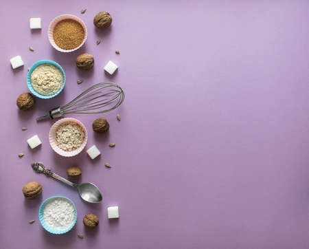 on a lilac background on the left layout chaos mess nut walnut sunflower seeds sugar cube refined corn spoon shape for cupcakes flour blue pinkの写真素材