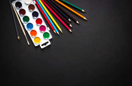 on a dark paint background brush pencils colored horizontal top view flat lay knollingの写真素材