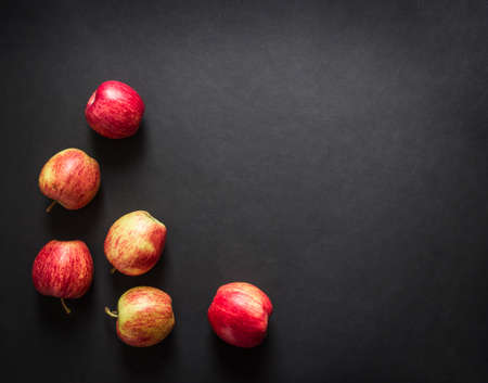 on a dark black background red yellow apples frame view from above flat lay horizontalの写真素材