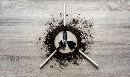 wooden background concept earth covered circle dish rake fork scapula knife texture planting center springの写真素材
