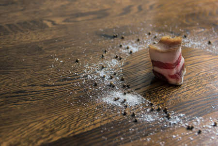 on a wooden background of cutlets of dark brown color circle sea salt large pepper seasoning coriander poured a piece of bacon fatの写真素材