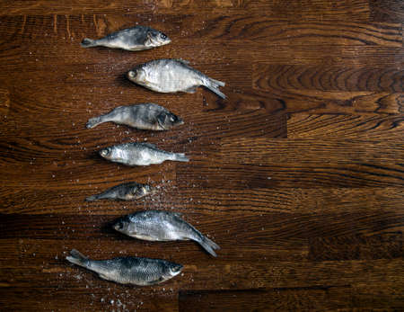 on a wooden background of small dark brown on the side lie salted dried fish large saltの写真素材