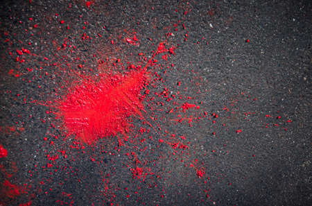 on a dark background of asphalt red stain from spray paintの写真素材