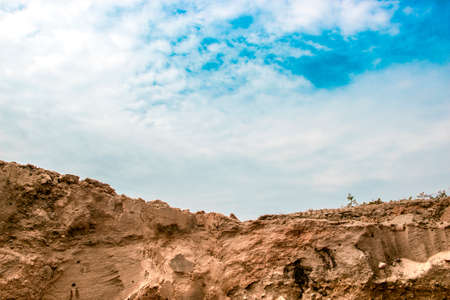 a section of a sand dump quarry sand dunes sand stones sky with cloudsの写真素材