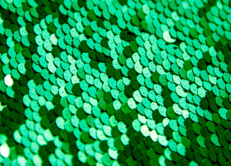 texture background round paillettes of silver color dark and light shine greenの写真素材
