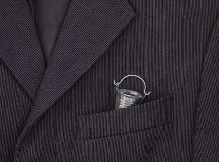 in a breast pocket of a dark black man's jacket in a light strip there is a bucketの写真素材