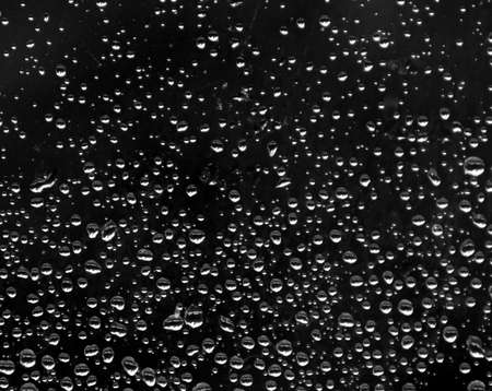 on a black background many drops of rain gradient size from big to smallの写真素材