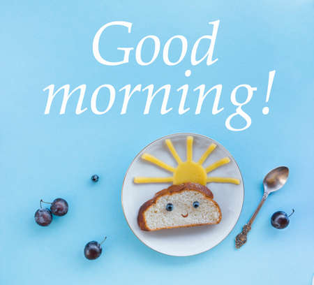 on a blue background breakfast morning sun cloud sky rays rays cute sandwich healthy food berries blueberries plum bread cheese plate spoon servingの写真素材