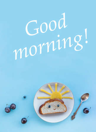 on a blue background breakfast morning sun cloud sky rays rays cute sandwich healthy food berries blueberries plum bread cheese plate spoon servingの写真素材