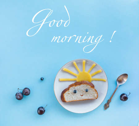 on a blue background breakfast morning sun cloud sky rays rays cute sandwich healthy food berries blueberries plum bread cheese plate spoon servingの写真素材