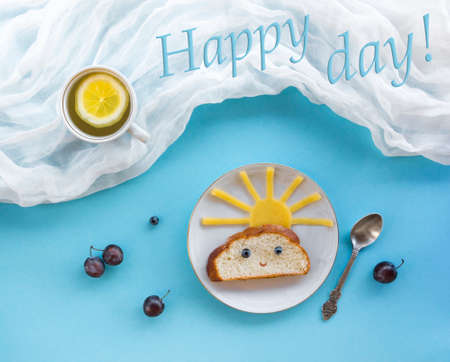 on blue background breakfast morning sun cloud sky rays joy cute sandwich healthy food berries blueberry plum bread cheese plate spoon serving napkin cup tea drinkの写真素材
