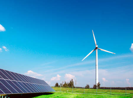 wind generator of electricity from three blades and solar panels of a battery of photocells against...