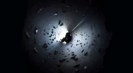 on a dark square background in the center of a round stream of light trumpet drops man sits afraid phobiaの写真素材