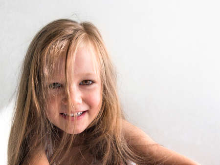 on white background beautiful dark-haired brunette girl with brown eyes and disheveled long hair smiling copy spaceの写真素材