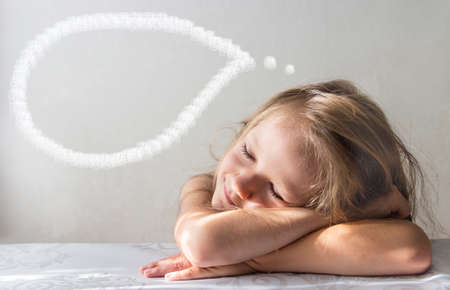 on a white background a sleeping smiling dream girl lies in the rays of the sun morning copy spaceの写真素材