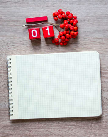 A blank sheet of a notebook on a spring pencil and a desk calendar cubes