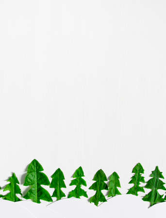on a light background in the background a line of Christmas trees made from dandelion leaves and white snow drifts sun flower applique children's copy spaceの写真素材