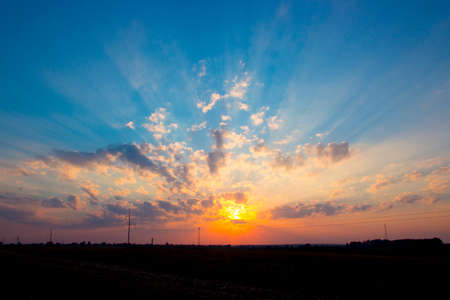 sunset dawn sun rays over the city skyの写真素材