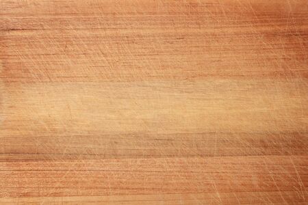 Wood texture in scratches. The texture of the wood is light orange in scratches. The texture of the wood cutting Board with a lot of scratches from the knife.の写真素材