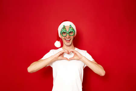 concept - love, people, relationships. young, joyful, excited man in Santa Claus New Year hat and...