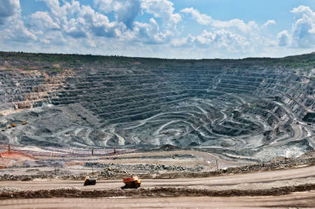  quarry extracting iron ore with heavy trucks, excavators, diggers and locomotivesの写真素材