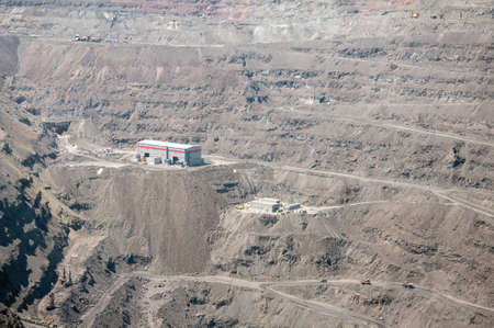 open cast mine extracting iron ore with heavy trucks, excavators, diggers and locomotives