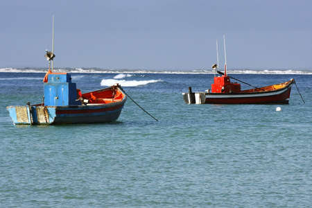 two colourful fishing boats moared in a small harbourの写真素材