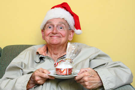 senior man about to eat some delicious christmas cakeの写真素材
