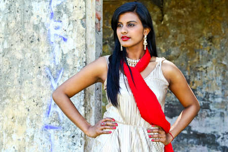 Attractive woman standing with her hands on her hips wearing a gold dressの写真素材