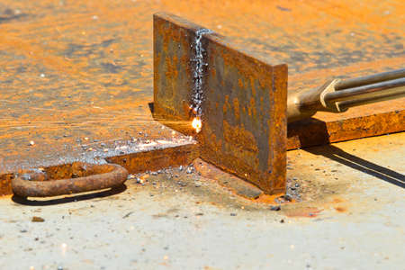 blow torch being used to cut through a thick piece of steel