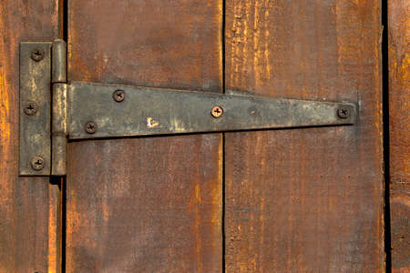 old wooden door with a rusty hinge attachedの写真素材