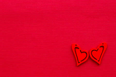 two red hearts on a red textured background