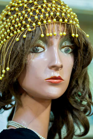 old damaged Mannequin head with fashionable beads and brown hair with shallow depth of fieldの写真素材