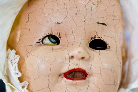 old grungy dolls face with hair line cracks and shallow depth of fieldの写真素材