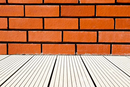 red brick wall background with some white decking leading up to itの写真素材
