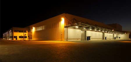 wide angle view of a modern warehouse at night in flood light lightの写真素材