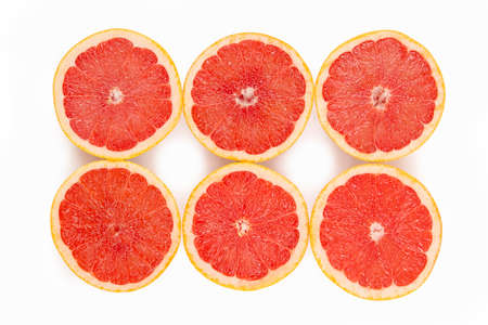 Six beautiful tasty half red grapefruit isolated on whiteの写真素材