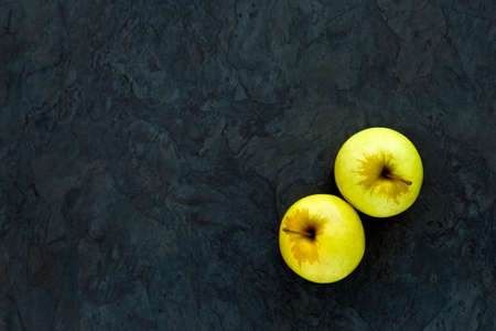 Two delicious ripe apples on a grey slate background with lots of copy spaceの写真素材