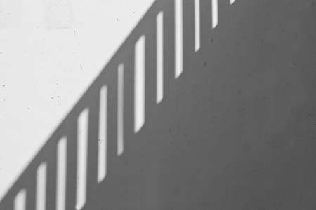 abstract view of a steel banister reflected on a wall in full sunshineの写真素材