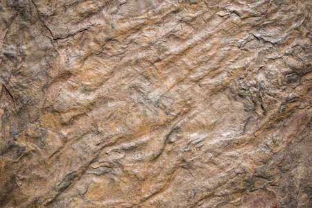 Abstract rough textured stone background with shades of brown and blackの写真素材