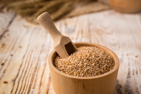 wheat groats in a bowl on a wooden background. Healthy dietary cereals concept.の写真素材