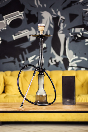 Hookah on the water stands on the wooden table with menu of tobacco. Shisha Conceptの写真素材