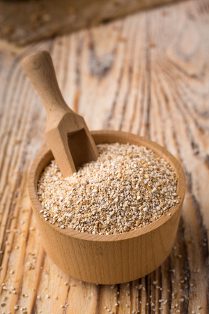 Barley groats in bowl on a wooden background. Healthy dietary cereals concept.の写真素材